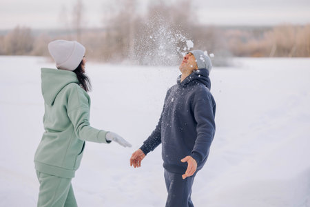 Happy couple playing winter game in forest outdoors. Love and leisure concept.の写真素材