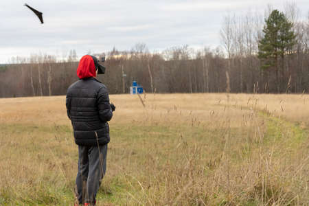 Young man launches rc plane into sky. Teenager with glasses playing with toy radio-controlled...
