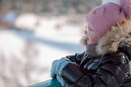 Little girl walks outdoors on winter snowy day in park. High quality photoの写真素材