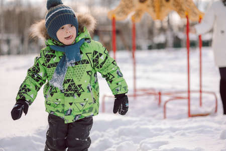 Portrait little boy walks on the playground on frosty winter day. High quality photoの写真素材