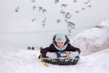 Little girl walks outdoors on winter snowy day in park. High quality photoの写真素材