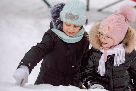 Little girls walks outdoors on winter snowy day in park. High quality photo