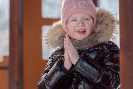 little girl warms her frozen ankles on a walk on a frosty winter day. High quality photo