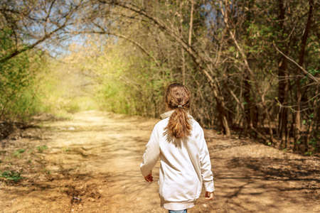 Little pretty girl on walk in sunny spring park. Fairy forest. High quality photoの写真素材