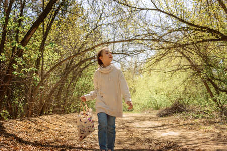 Little pretty girl on walk in sunny spring park. Fairy forest. High quality photo