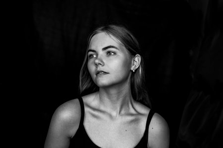 Close-up portrait of caucasian blonde girl with long hair. Black and white photo. High quality photoの写真素材
