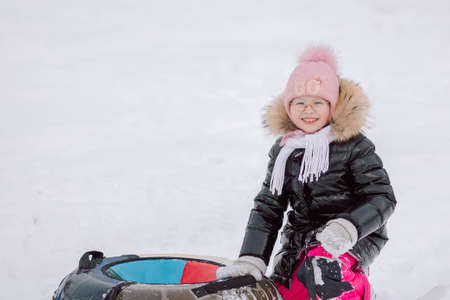 Little girl walks outdoors on winter snowy day in park. High quality photoの写真素材