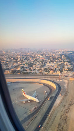 UAE, Dubai - November 26, 2021: View from the window of plane on blue sky and earth with landscape...
