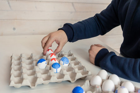 Two men are playing chess with Easter eggs at white table. Creative ideas for unusual chess....