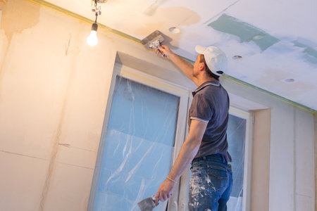 Worker make repairs in new apartment. Man plaster walls and ceilings. High quality photoの写真素材