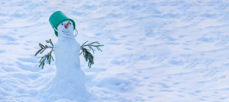 Happy snowman on snow in winter new year landscape. Beautiful Christmas snowy background, banner format, copy space. High quality photoの写真素材