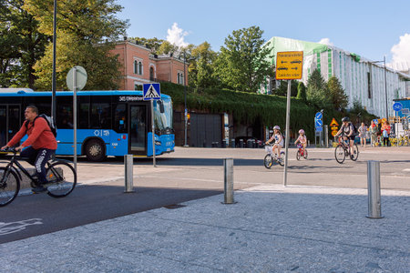 Helsinki, Finland - August 22, 2022: Cyclists in protective helmets ride along bike path in city center on Kansalaistori Squareのeditorial素材