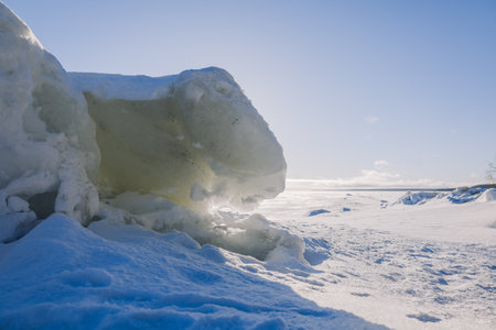 winter landscape. Panoramic view of beautiful sunset on bay. Ice, snow and rocks on coastline....