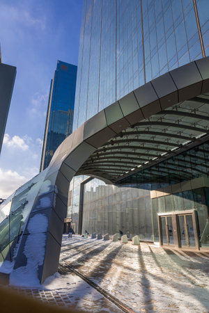 Astana, Kazakhstan - November 23, 2022: Modern architectural urbanistic entrance to skyscraper. Abstract geometric background with sun reflection and shadows. Interior building with glass windowsのeditorial素材