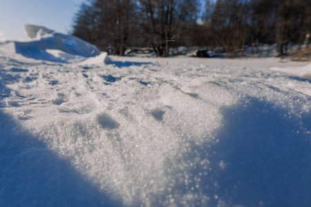 Winter landscape. Panoramic view of beautiful sunset on bay. Ice, snow and rocks on coastline. Setting sun in bright light. High quality photoの写真素材