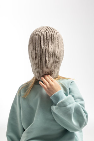 Portrait of beautiful cute little toddler girl. Child with funny face in mint sweatshirt and hat. Pretty smile kid in studio on white background.の写真素材
