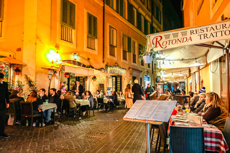 Italy, Rome - November 26, 2023: Old cozy street Illuminated at night. Architecture of Rome. Cafes and restaurants in Christmas lights, Italyのeditorial素材