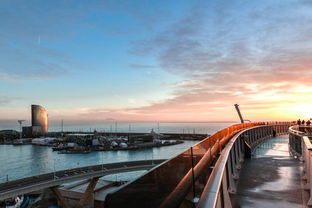 Barcelona, Spain - December 1, 2023: Panoramic view of cargo port in Barcelona. Freight transportation by container ship in harbor morning at dawn with beautiful sky with cloudsのeditorial素材