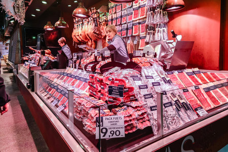 Barcelona, Spain - December 1, 2023: Barcelona market on La Rambla street. Spanish cured ham hanging in Boqueria Marketのeditorial素材