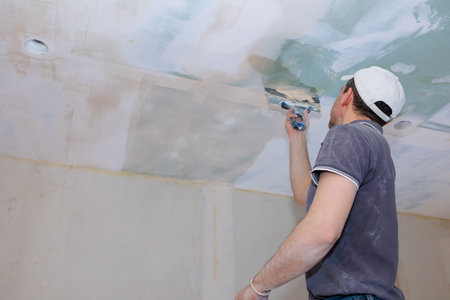Worker make repairs in new apartment. Man plaster walls and ceilings. High quality photoの写真素材