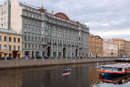 Saint Petersburg, Russia - July 13, 2023: People on SUP boards float along Moyka River in early serene morning of beautiful city, St. Petersburg, Russiaのeditorial素材