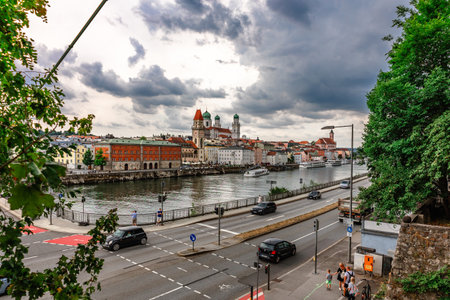 Passau, Germany - July 21, 2023: Panoramic view of Passau. View through tree branches. Aerial skyline of old town with beautiful reflection in Danube river, Bavaria, Germany.のeditorial素材