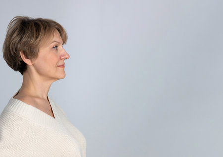 Portrait of successful mature woman. Confident woman on light gray background. Profile View, banner....