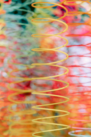 Lots of bright colorful spirals. Abstract blurred background with selective focus on waves. Vertical photoの写真素材