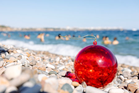 Christmas ball on beach sea background. Concept of New Years holidays in exotic countries. Selective focus. High quality photoの写真素材