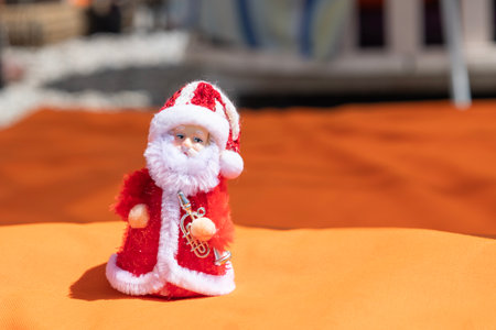 Santa Claus figurine on red orange background. Concept of New Years holidays in exotic countries. Selective focus. High quality photoの写真素材