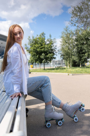 Beautiful girl with long hair rollerblading in park. Roller skating quads - popular and safe type of...