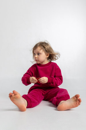 Portrait of cheerful playing girl. Child with smiles and funny emotions on light background. Vertical photoの写真素材