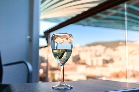 Glass of white wine on table in sunlight. Atmosphere of delightful eventの写真素材