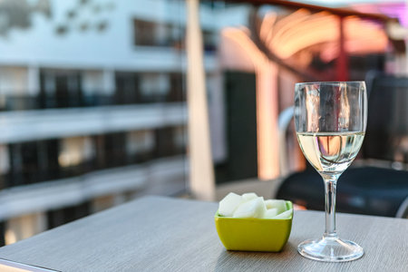 Glass of white wine cafe and fruit light snack on table in sunlight. Atmosphere of delightful event and romantic summer. High quality photoの写真素材