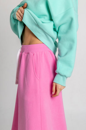 Beautiful woman in mint color sweatshirt and pink skirt. Vertical photo. High quality photoの写真素材