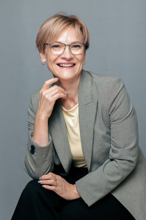 Portrait of happy woman. Confident, successful mature woman on light gray background. Looking at camera. High quality photoの写真素材