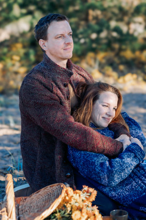 Portrait happy beautiful couple in love enjoying autumn picnic in autumn park. Vertical photo. High quality photoの写真素材