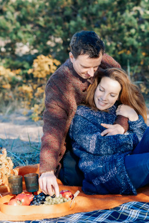 Portrait happy beautiful couple in love enjoying autumn picnic in autumn park. Vertical photo. High quality photoの写真素材
