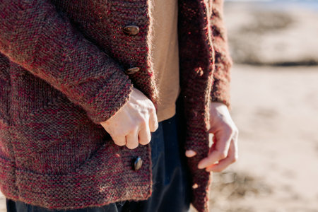 Male hands close-up. Young carefree couple in love throwing pebbles, shells, stones into sea outdoors. Fun family game together. High quality photoの写真素材
