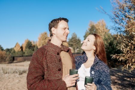 Happy beautiful couple in love enjoying autumn picnic in park. Weekend and lifestyle concept. High quality photoの写真素材
