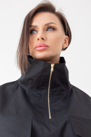 Portrait of beautiful woman in black jacket close-up on white background. Studio photography. Vertical photo. High quality photoの写真素材