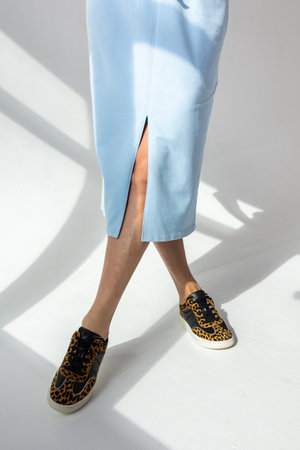 Close-up of light blue skirt on white background. Fashionable female style. Studio photography. Vertical photo. High quality photoの写真素材