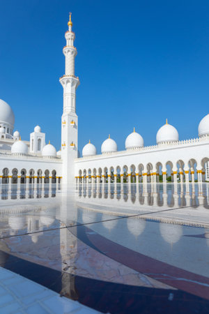 View of Sheikh Zayed Grand Mosque in Abu Dhabi made of white marble with flowers made of precious stones in design and beautiful reflections. Vertical photoの写真素材
