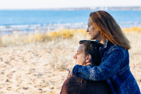 Loving couple walks on beach along sea on sunny autumn day. Weekend and lifestyle concept. High quality photoの写真素材