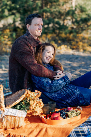 Portrait happy beautiful couple in love enjoying autumn picnic in autumn park. Vertical photo. High quality photoの写真素材