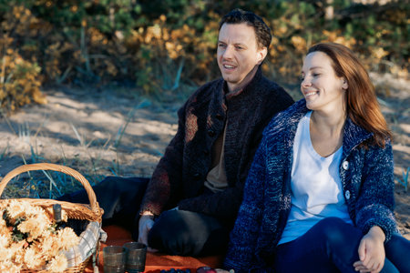 Portrait happy beautiful couple in love enjoying autumn picnic in autumn park. High quality photoの写真素材