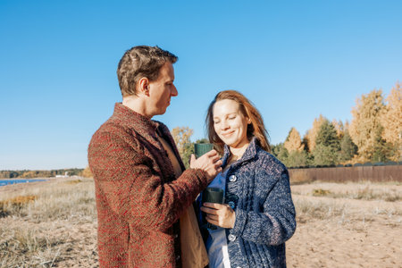 Happy beautiful couple in love enjoying autumn picnic in autumn park. Weekend and lifestyle concept. High quality photoの写真素材