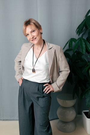 Happy woman. Confident, successful mature woman on light gray background. Looking at camera. High quality photoの写真素材