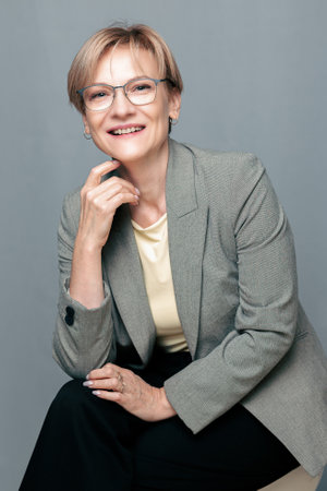 Portrait of happy woman. Confident, successful mature woman on light gray background. Looking at camera. High quality photoの写真素材