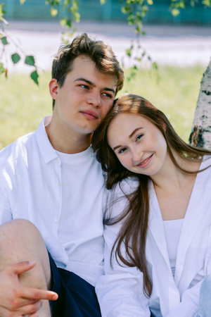 Close-up portrait of couple in love. Young woman and men walking and having fun in park on warm summer day. Vertical photo. High quality photoの写真素材
